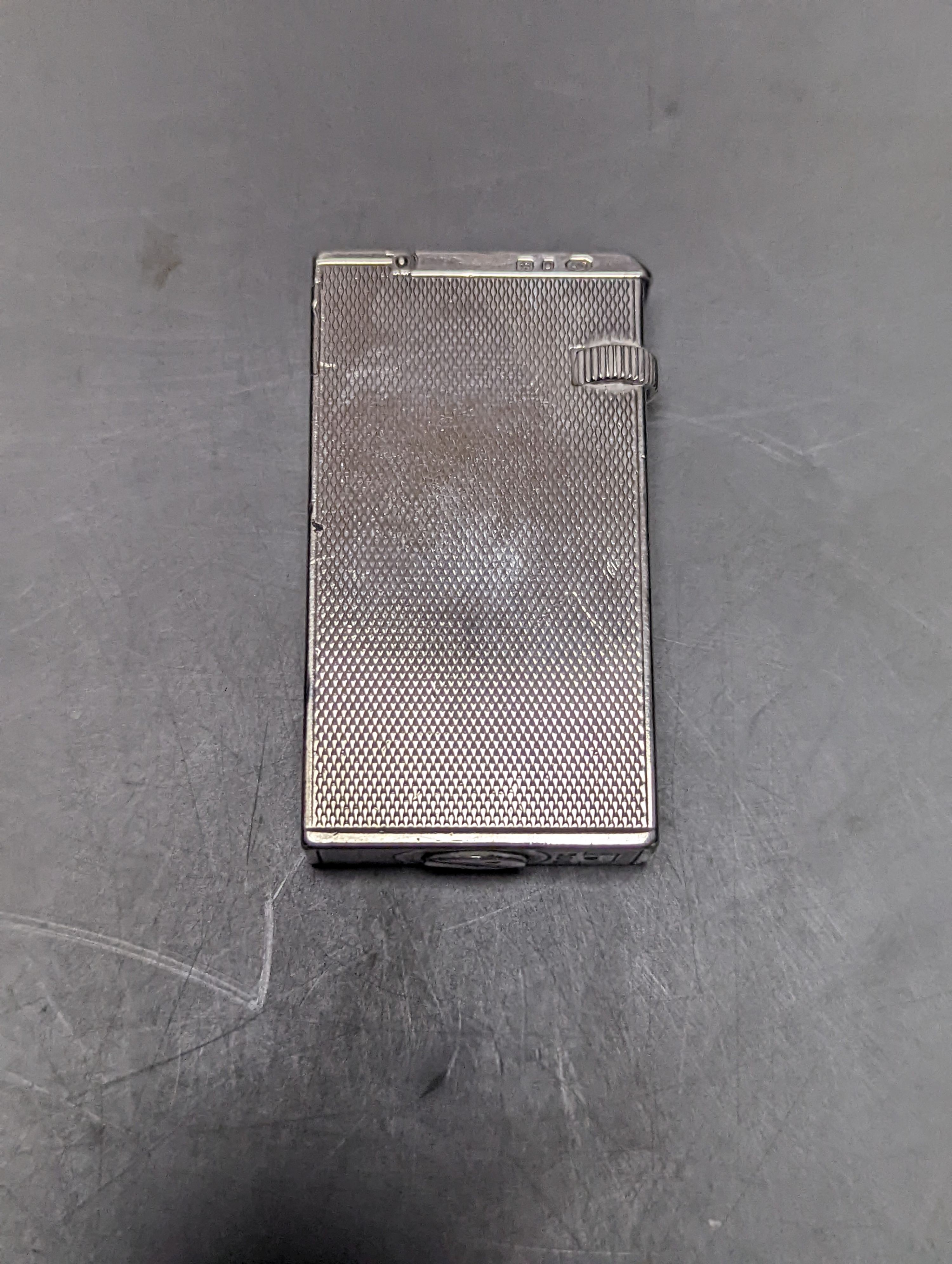 A George VI engine turned silver mounted Dunhill lighter, London, 1945, 57mm.